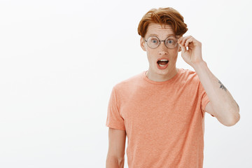 Cute redhead male geek discussing with mates new computer game, talking with passion and...