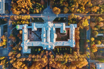 Top view of old building architecture in autumn city landscape with yellow trees and urban traffic