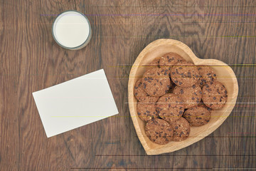 food, junk-food, culinary, baking and eating concept - chocolate oatmeal cookies on plate and milk glass with message paper