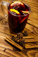 Mulled wine and spices on wooden table