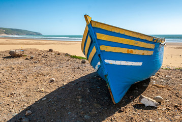 Fototapeta na wymiar Fisherman's boat stranded on the beach of Tafelney, in the region of Essaouira in Morocco
