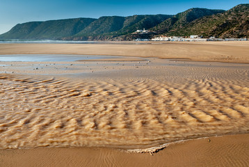 The wind creates ripples on the sea at low tide on the beach of Tafelney in the region of Essaouira...