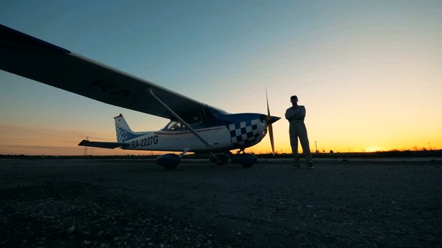 Runway landing with a male aviator and his small aircraft during sunset