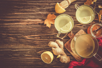 Autumn hot drink - ginger, lemon, honey tea and ingredients, wood back