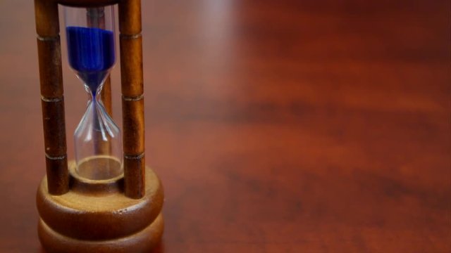 Hourglass close up on table with large copyspace, time passing concept