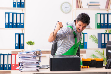 Young engineer repairing broken computer at the office 