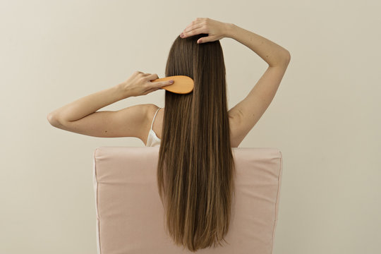 image of attractive woman brushing her  long hair