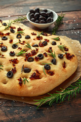 Homemade Italian focaccia with sun dried tomatoes, black olives and rosemary