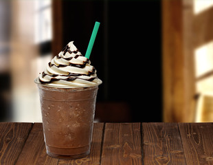 Frappuccino in takeaway cup on wooden table isolated on cafe background - obrazy, fototapety, plakaty