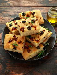 Homemade Italian focaccia with sun dried tomatoes, black olives and rosemary