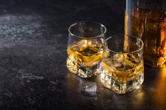 Whiskey with ice in glasses and bottle