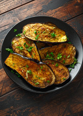 Healthy vegeterain Oven baked aubergines, Eggplant with parsley and herbs in a black plate
