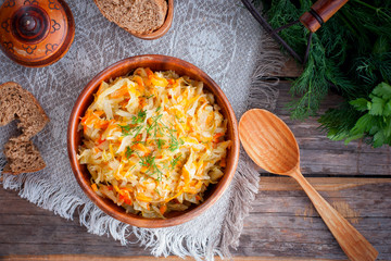 Braised cabbage in a wooden bowl, top view, selective focus