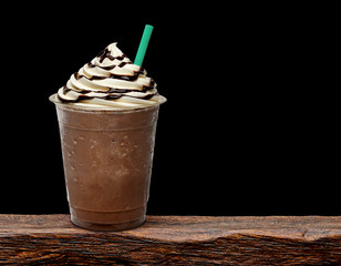 Frappuccino in takeaway cup on wooden table isolated on cafe background