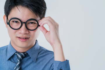business asian male in blue shirt  hand touch round black glasses focus and concentrate