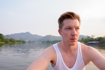 Fototapeta na wymiar Tourist man sitting in boat while having holiday in Thailand