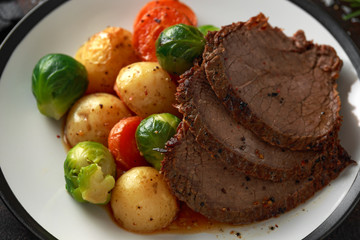 Sliced Roast beef with honey glazed vegetables, served on plate. festive dinner