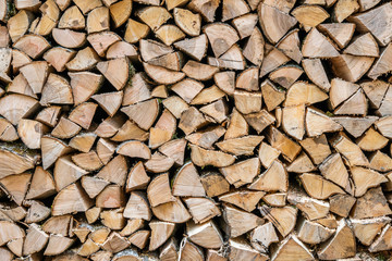 a stack of chopped firewood lies in the yard