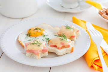 Breakfast with fried egg and hot sandwiches with sausage and cheese, horizontal