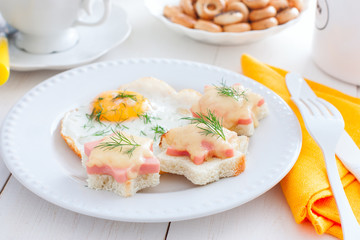 Breakfast with fried egg and hot sandwiches with sausage and cheese, horizontal