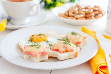 Breakfast with fried egg and hot sandwiches with sausage and cheese, horizontal