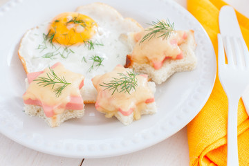 Breakfast with fried egg and hot sandwiches with sausage and cheese, horizontal