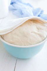 Yeast fresh raw dough in a blue bowl, selective focus