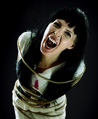 Crazy bloody scary zombie woman screams at camera