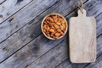 Almond nut in wooden bowl on wood table background, copy space