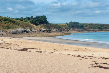 French landscape - Bretagne. Beautiful sandy beach with rocks in the background.