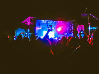 The party, concert concept. Crowd raising their hands and enjoying great rock festival. blur bokeh for background.