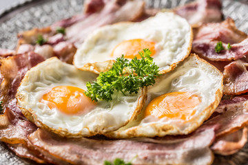Close-up roasted bacon and egg with herbs.