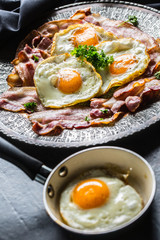 Close-up roasted bacon and egg with herbs.