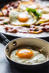 Close-up roasted bacon and egg with herbs.