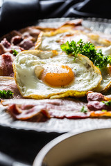 Close-up roasted bacon and egg with herbs.