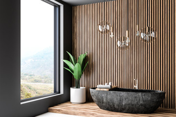 Wooden bathroom corner, black tub and window