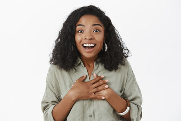Close-up shot of delighted amused and happy young charming african american woman with curly...