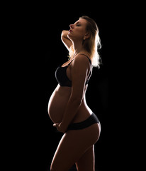 Artistic silhouette of blonde pregnant woman on isolated background