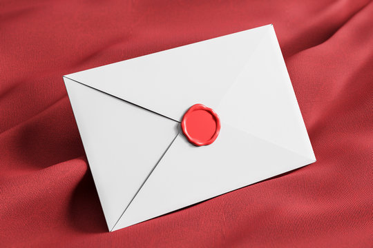 Closed white envelope on red tissue