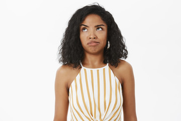 Waist-up shot of clueless and questioned silly african american girl trying understand what made...