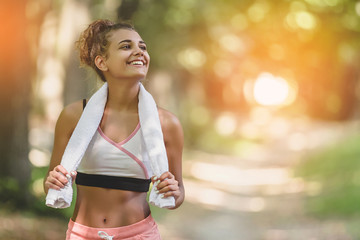Portrait young attractive smiling fit woman with white towel resting after workout sport exercises...