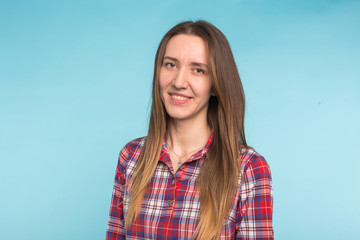 Close-up portrait of young caucasian smiling woman on blue background