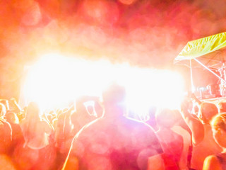 The party, concert concept. Crowd raising their hands and enjoying great rock festival. blur bokeh for background.