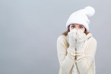 Young woman in a cold weather winter outfit on a gray background