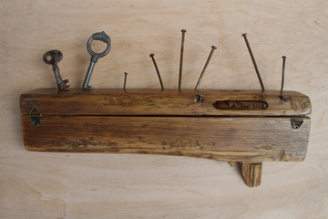 Wooden rustic style handmade key holder with rusty nails and keys