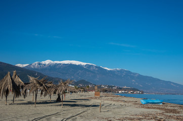 Sand beach in Nei Pori village with Olympus mountain at background. Sunny winter day. Pieria, Greece.