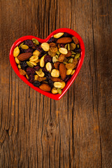 Energy Blend Trail Mix with Nuts and Dried Fruits in Heart Shaped Bowl. Selective focus.