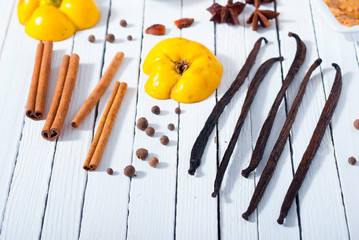 quince jelly and ingredients on white wooden table background