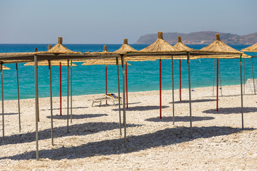 Umbrellas on the Borsh Beach in Albania. Stony beach on the Adriatic Sea.