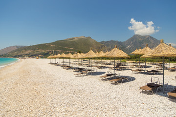 Umbrellas on the Borsh Beach in Albania. Stony beach on the Adriatic Sea.